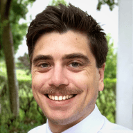 Confident young businessman smiling outdoors, representing professional success and positive client relationships for web design services.