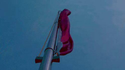 Animated GIF of a red flag waving against a blue sky