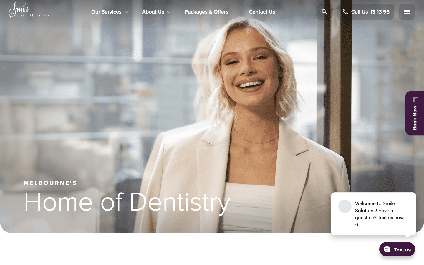 A smiling woman in a professional setting, representing a friendly dental practice.